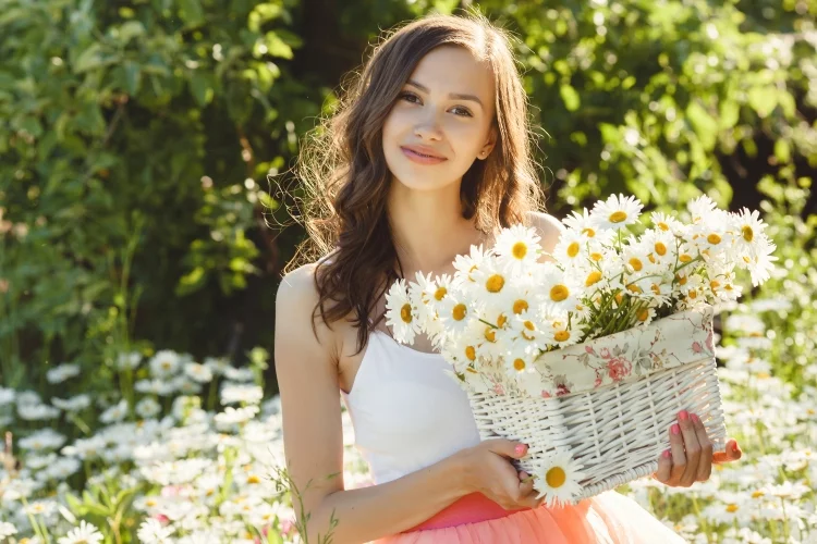 Beautiful woman in chamomile field in the summer.